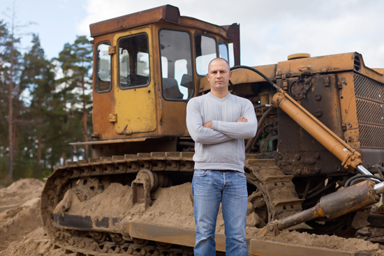 Septic contractor standing in front of a bulldozer